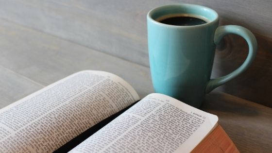 Bible on table next to coffee in teal mug